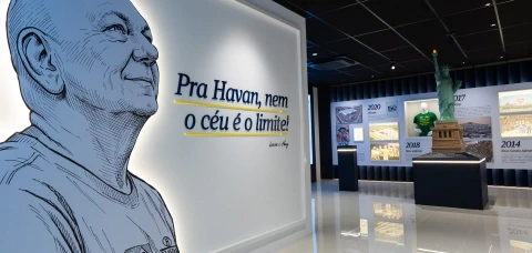 Painel interativo no Museu Havan com foto e biografia do fundador Luciano Hang em ambiente iluminado